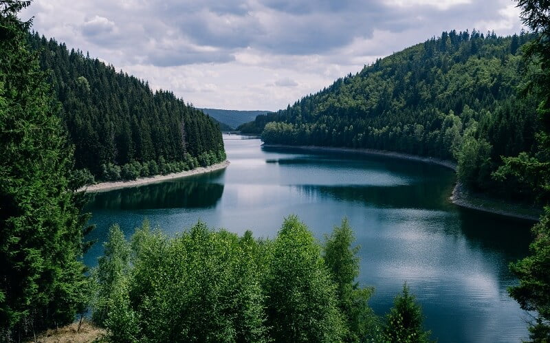 River surrounded by forests under a cloudy sky in thuringia in germany